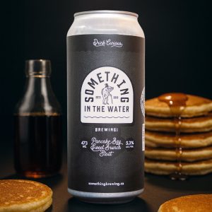 Pancake Bay Sweet Brunch Stout can beside stacks of pancakes and maple syrup